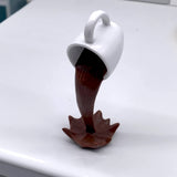 Xícara Decorativa Flutuante com Café Derramando – Escultura para Amantes de Café