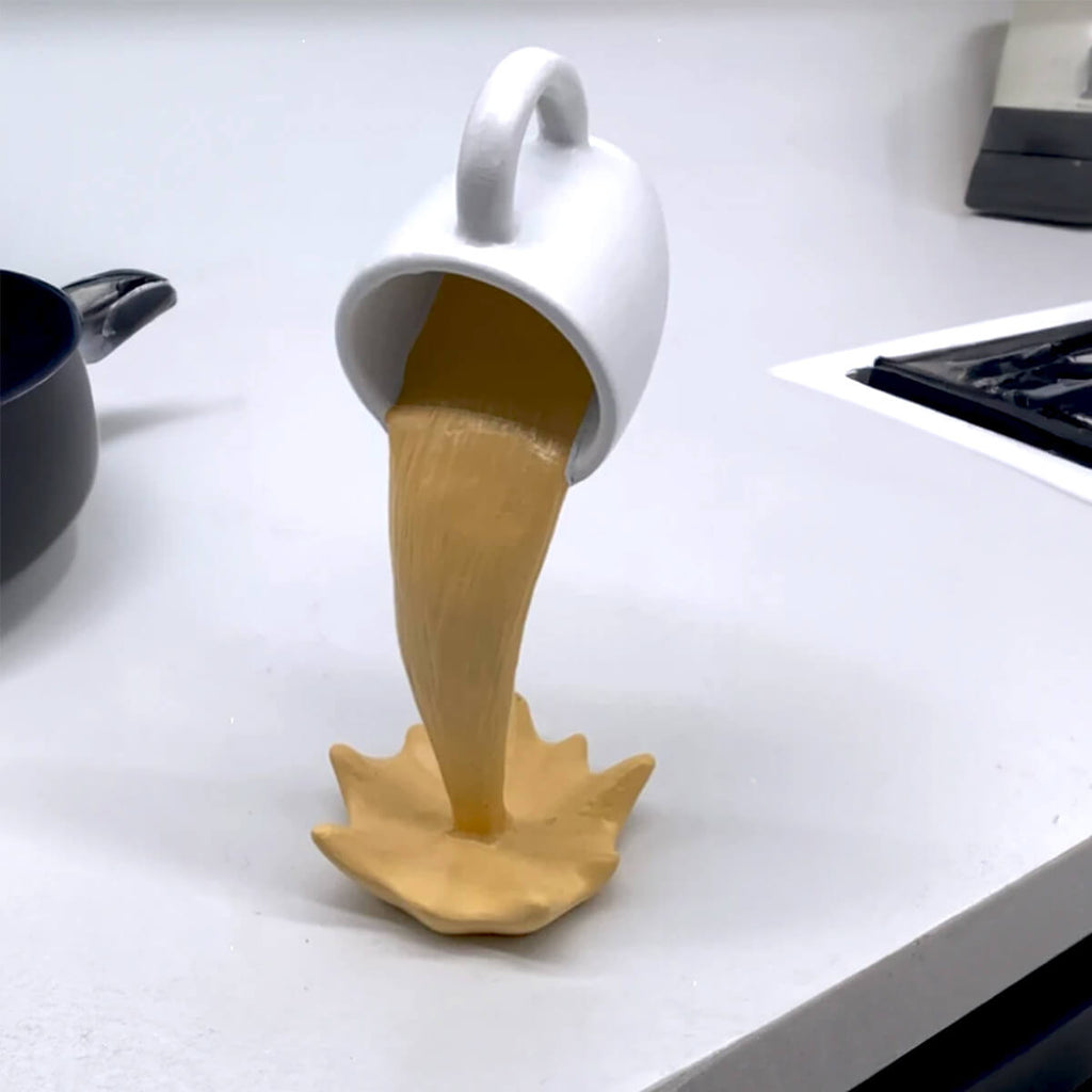 Xícara Decorativa Flutuante com Café Derramando – Escultura para Amantes de Café