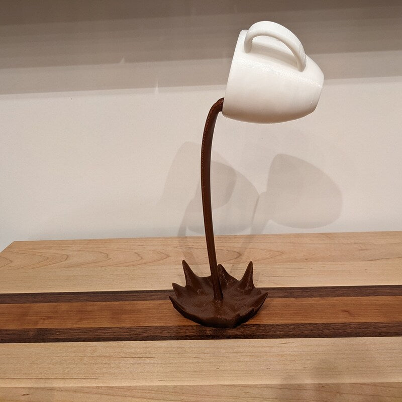 Xícara Decorativa Flutuante com Café Derramando – Escultura para Amantes de Café